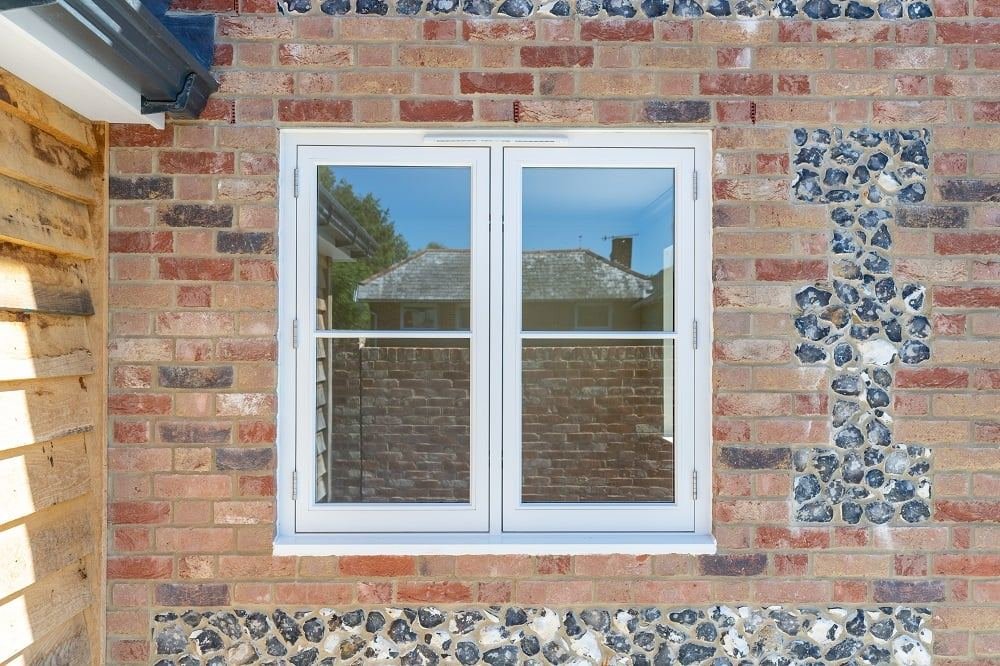 Casement window in a flint and brick wall